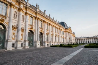 Façade extérieure d'un palais royal luxueux avec colonnes en marbre, dorures baroques et jardins formels symétriques
